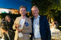 Frederik Madsen, CTO, holding the M-Files Solution Partner of the Year award, and Steen Madsen, CEO, both of CtrlDocs, at an outdoor evening event during M-Files IMPACT 2025